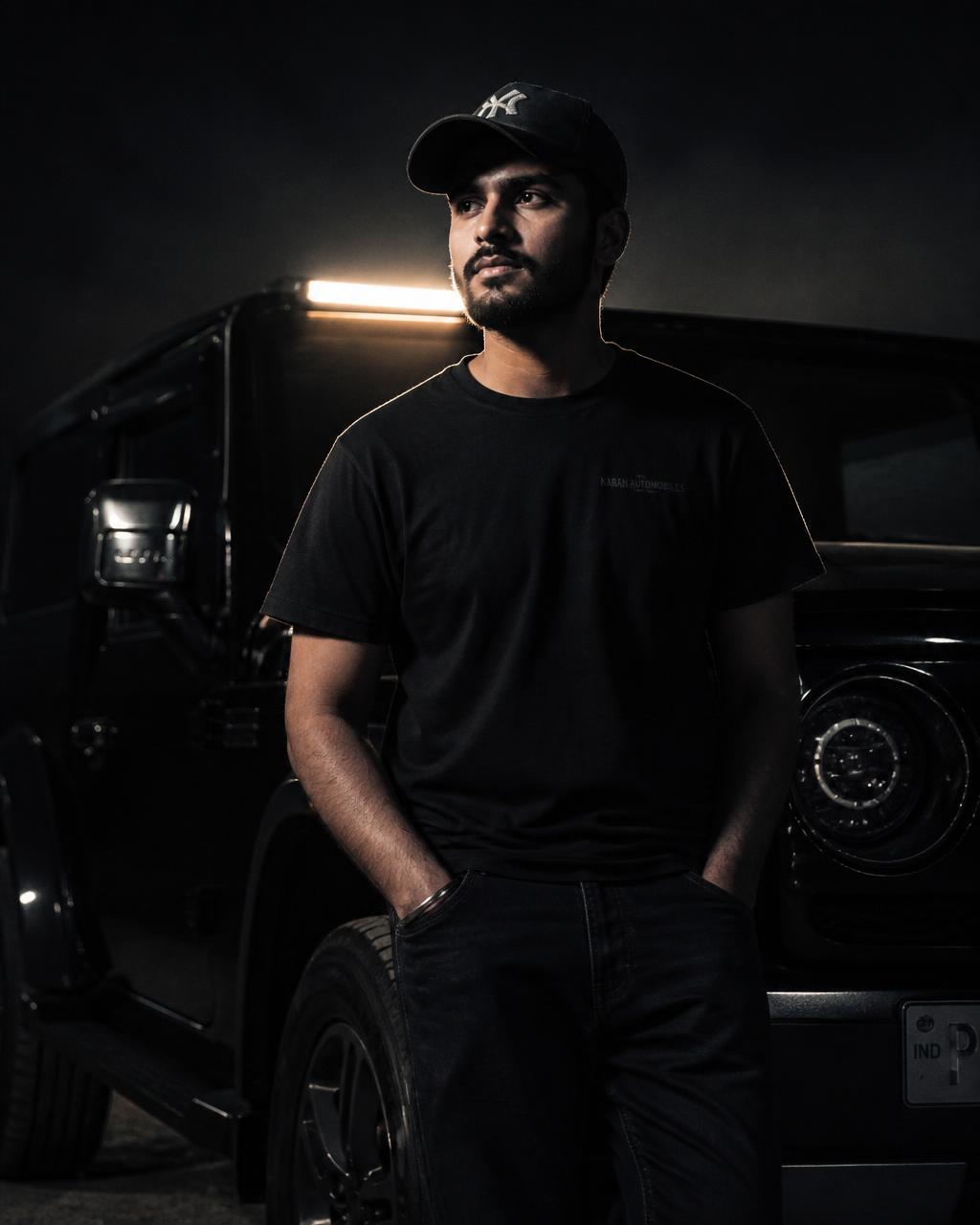 Panth Bhandari, Punjabi automotive creator, beside a dark SUV at night